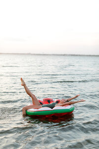Picture of a girl on a watermelon float in the middle of the bay in Ocean City, NJ.