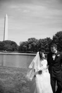 Virginia Wedding Photographers | a blurry black and white picture of a bride and groom in DC with the Washington Monument in focus in the background.