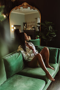 Seductive boudoir session with a girl in button up blouse.