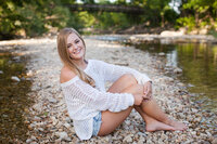 Senior picture of a girl on a creek sandbar