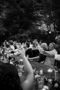 Guests raising their glasses in a black and white photo.