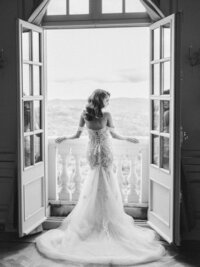 Bride in the middle of windows looking at the sea