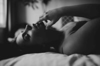 boudoir photo of woman posing against bed