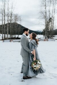Bride & groom hugging in snowy meadow near Leavenworth!