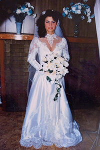 woman in vintage wedding dress with lace and holding flowers
