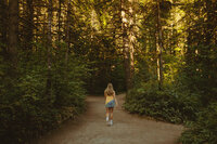 girl standing in woodland area for senior portrait