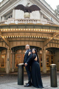 Couple posing romantically at entrance of Grand Central Station entrance.