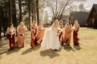 Bride and bridesmaid laughing under pine trees at Strawberry Arizona wedding.