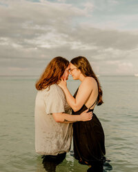 lesbian couple embracing & kissing on beach in PCB florida