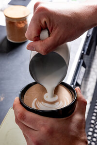 Barista preparing espresso at Grain Artisan Bakery in Snohomish, WA, highlighting the 2023 upgrade to single-origin coffee and locally sourced milk.