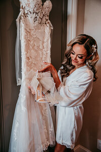 Bride smiling while adjusting her dress in a getting-ready suite before her San Francisco elopement, captured by San Francisco elopement photographer Kristin Smith.