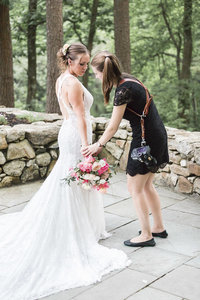 Photographer holding bride's dress train