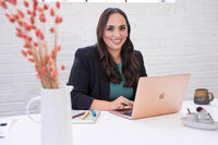 Stephanie, Founder of BCWise Consulting, sitting at a desk on a laptop 