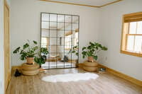 Alyn Wellness Studio space with plants,candles, and a big mirror on the wall