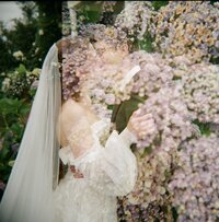 Bride and groom embracing during a first look in a nursery, surrounded by hydrangeas, captured by a Washington state wedding photographer.
