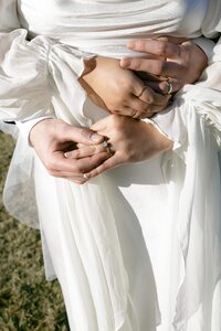 A bride looks back over her shoulder in a sunny field.