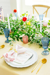 Table setting decorated with colorful florals and candlesticks