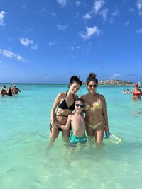 Sonia and her kids standing in tropical ocean water