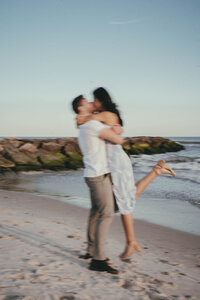 man and woman standing on a beach embracing