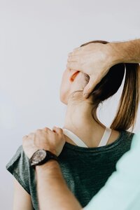 girl getting neck adjusted at chiropractor's office
