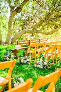 ceremony wedding with aisle of flower bouquets and tall green trees summer Prescott Skull Valley at Van Dickson Ranch