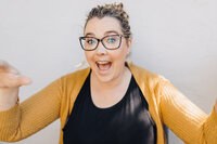 woman with open mouth smiling at the camera.