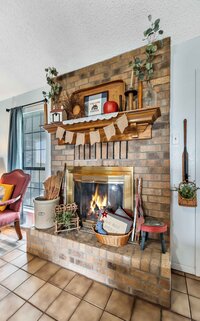 Brick fireplace in the living room of this 3-bedroom, 2.5 bathroom rural vacation rental house just minutes outside of downtown Waco, TX.