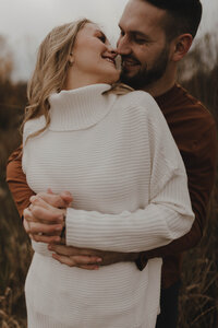 Couple laughing for engagement photos in West Salem, WI