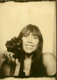 A photo of the photographer Stephanie Klotz in a photobooth holding a camera