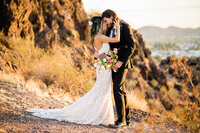 A bride and groom holding  a wildflower bouquet for their  mountain elopement in Arizona.
