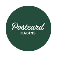 Green circle with “Postcard Cabins” in white script.
