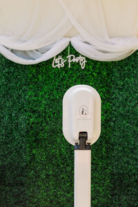 Photo booth in front of floral arbor