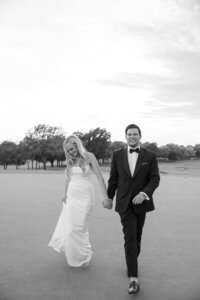 A bride and groom share a walk through the iconic hills of a country club in Tulsa, Oklahoma.