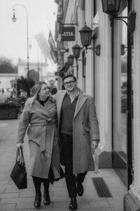 A cool couple walks down a street.