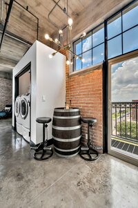 Edgy barrel seating for two near the balcony of this one-bedroom, one-bathroom condo in the historic Behrens building in downtown Waco, TX