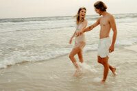 Couple holding hands walking on beach