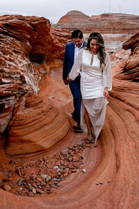 A couple sharing a magical engagement moment at sunset, with the golden light reflecting off the calm waters of Lake Powell.