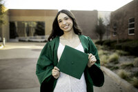 Confident high school senior standing with her back to the school, symbolizing the end of one chapter and the beginning of another. Wearing her cap and gown, she gazes forward with a sense of accomplishment and excitement, ready to embrace the future beyond high school