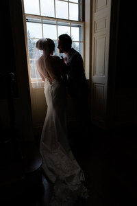 Moody silhouette couple in front of a window