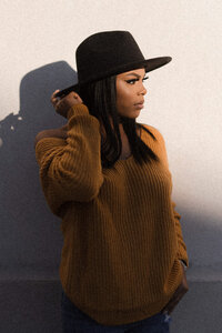 Senior girl with hat against wall