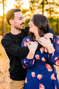 couples hugging each other smiling and laughing at at golden hour in Buffalo Park in Flagstaff Arizona engagement photos