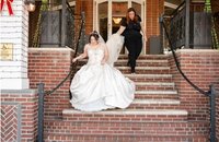 Casey, Founder of Most Valuable Bridesmaid behind the scenes at wedding with New Jersey Bride holding train while bride walks down the stairs.