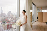 groom standing in front of red wall