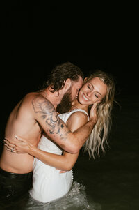 flash photography couples photo in lake Michigan at night