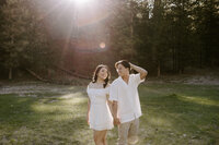 A couple stands back to back with their heads turned towards each other at Mt Charleston
