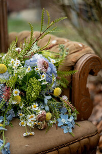 Large floral arrangement sitting on a couch outdoors