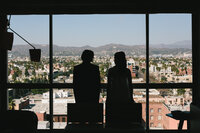 couple looking out window at Los Angeles skyline