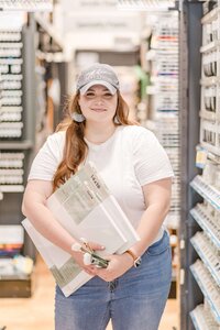 Elyse Stokes in an art supply store, selecting paint and canvases with confidence for an upcoming wedding painting
