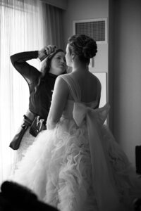 Black adn white photo of a bride with curls styled into a tight, elegant updo — a romantic, fairytale-inspired bridal hairstyle by Klover Beauty for a Maryland wedding.