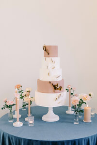 Four tier white and mauve wedding cake